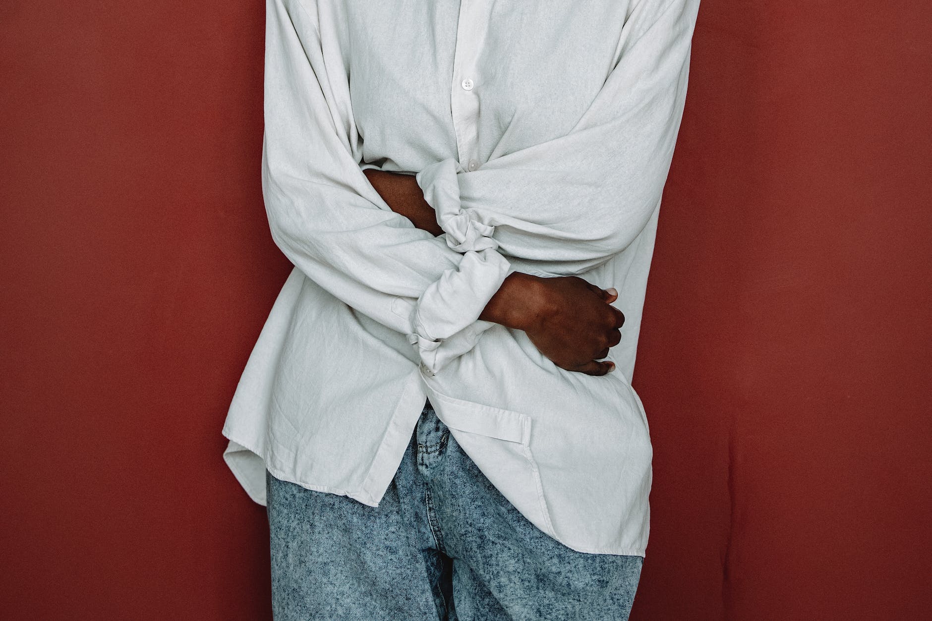 a person in white ling sleeve shirt holding her waist