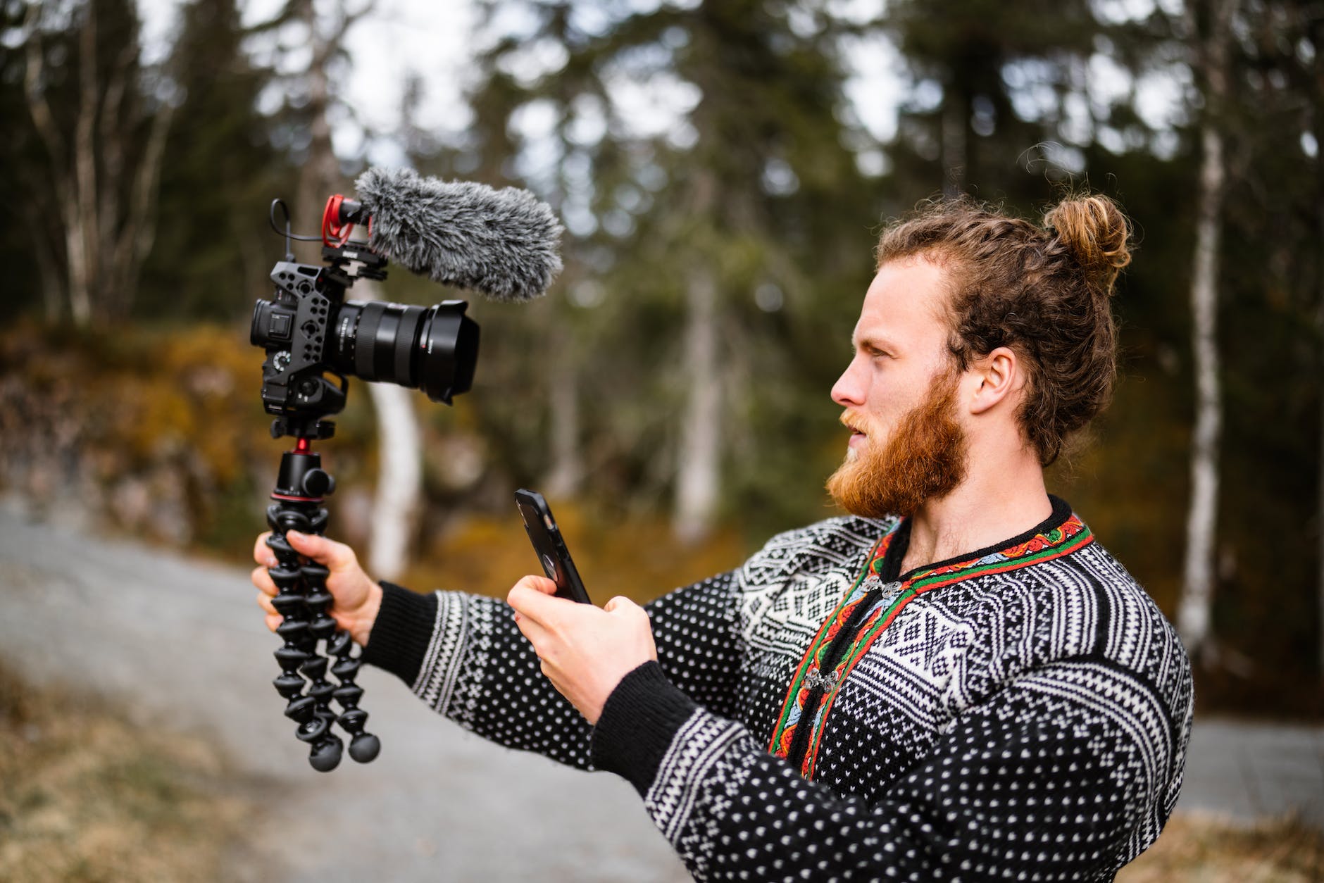 man with professional camera filming outdoors