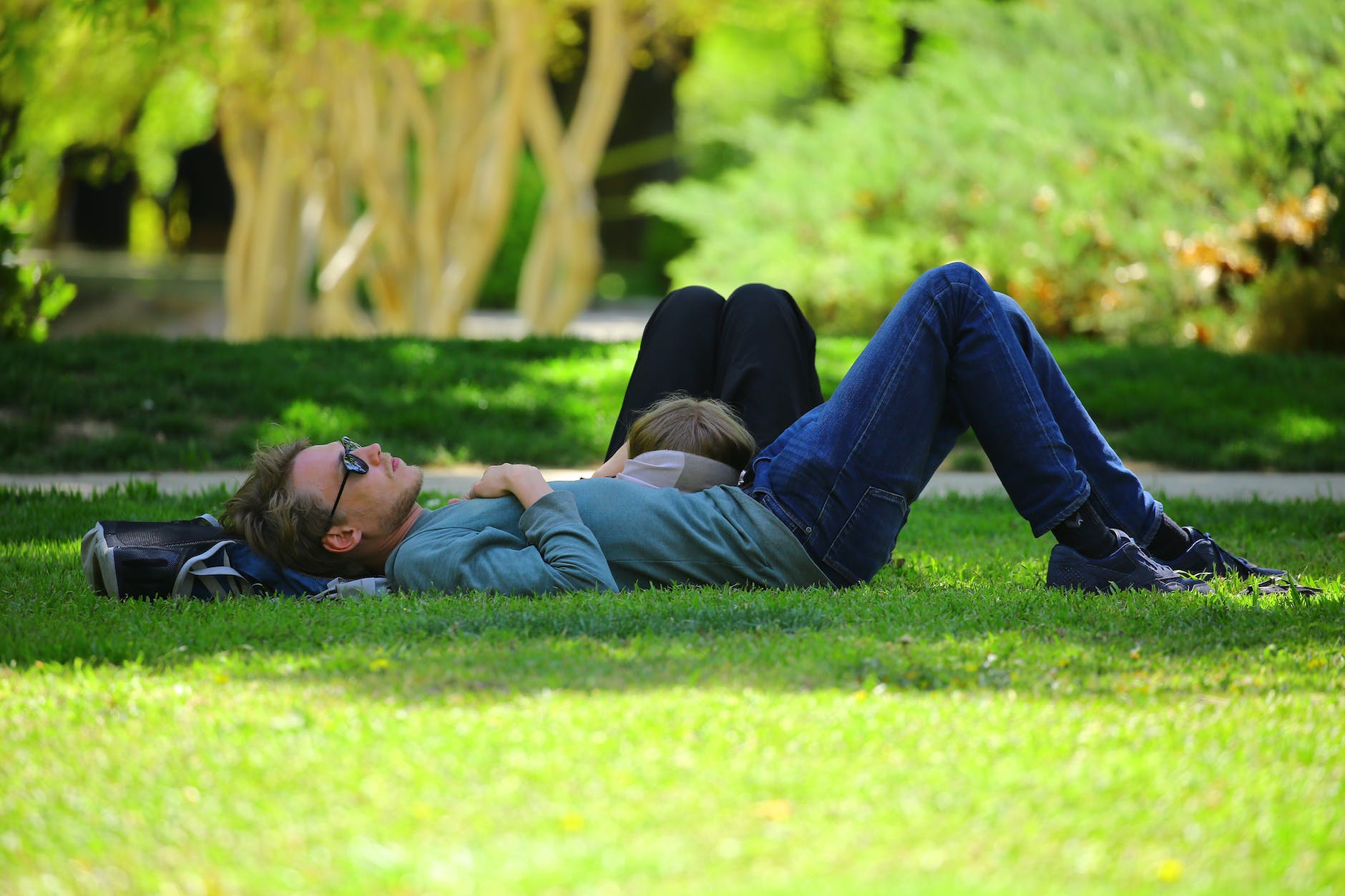 man wearing blue long sleeve shirt lying on ground during daytime