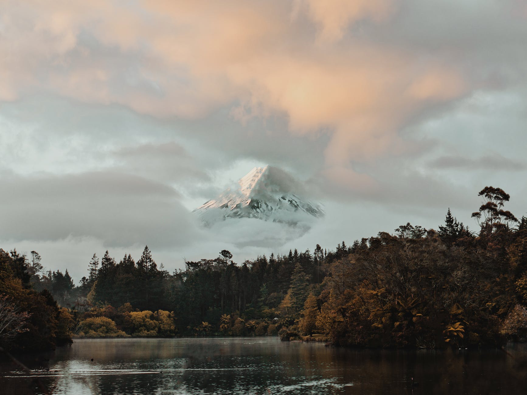 snowy mountain peak covered by clouds