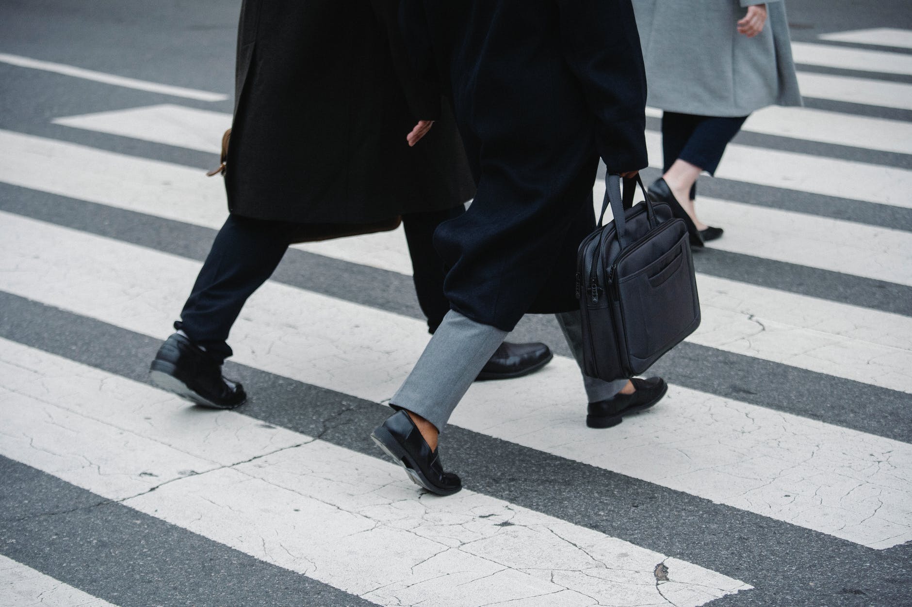 crop businesspeople strolling on crosswalk in town