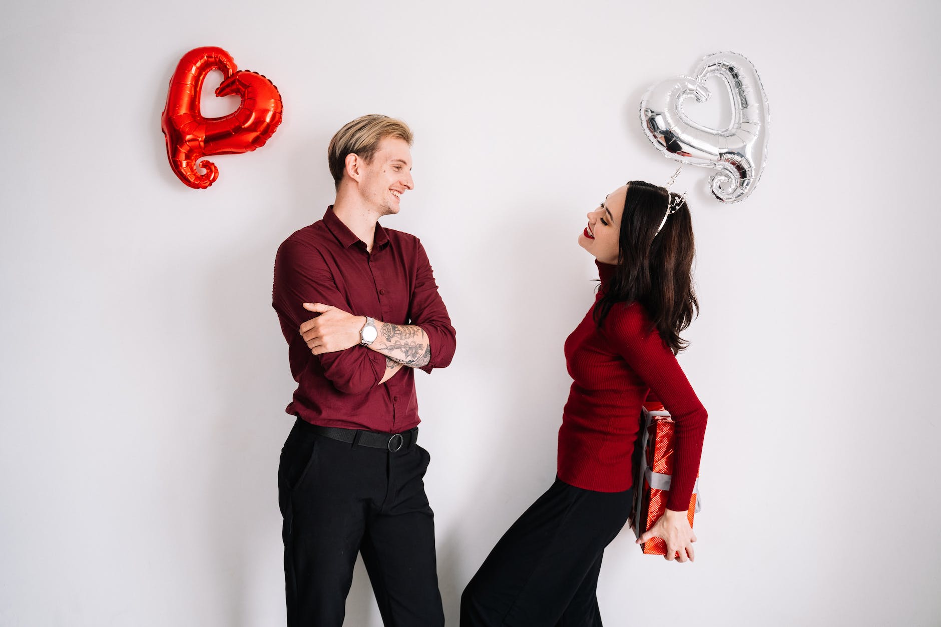 woman holding a surprise gift for man in front of her