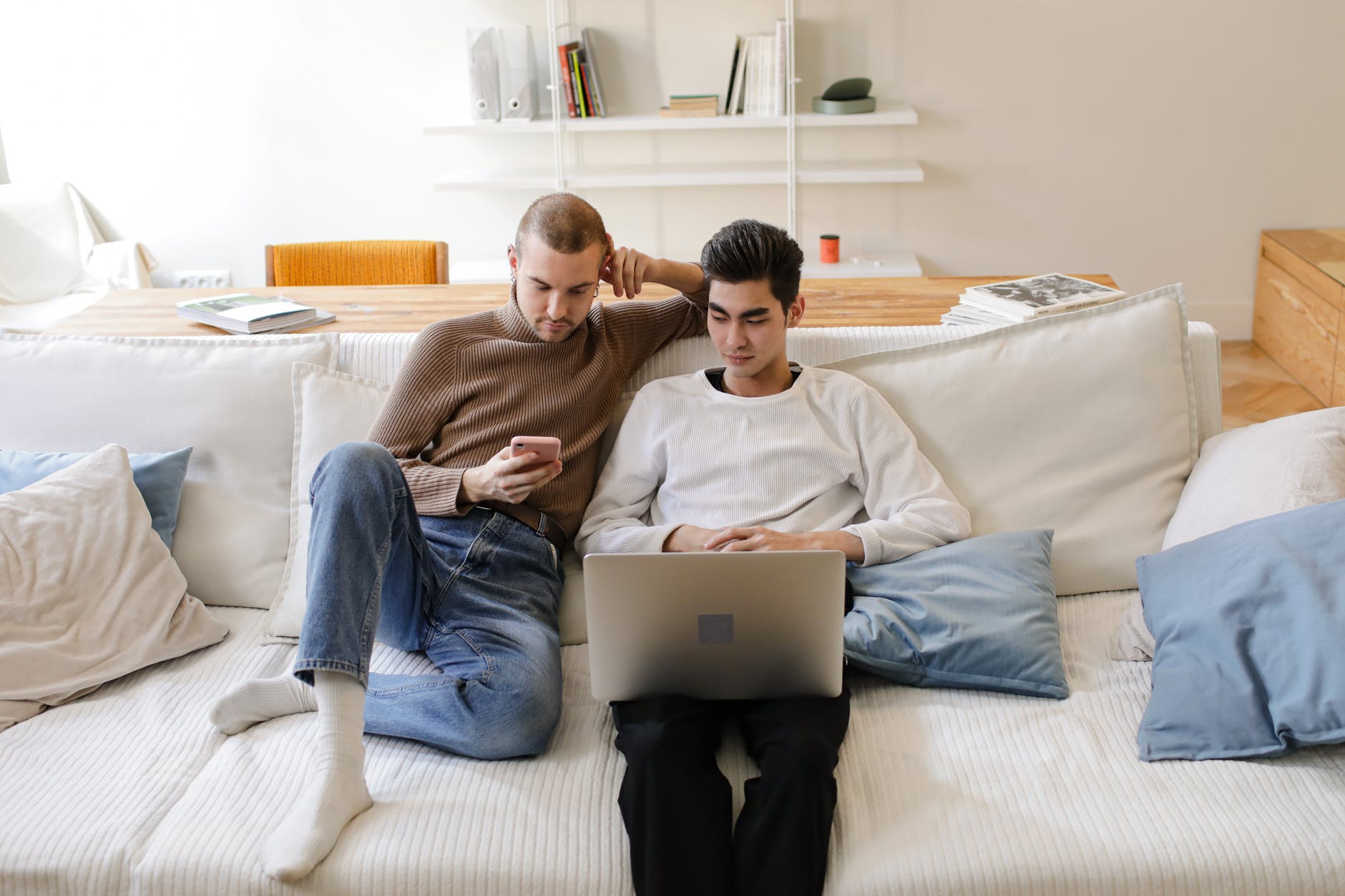 a man using a laptop looking at a man using a cellphone